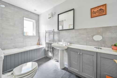 a bathroom with a toilet and a sink and a tub at Riverside B&B in Moretonhampstead