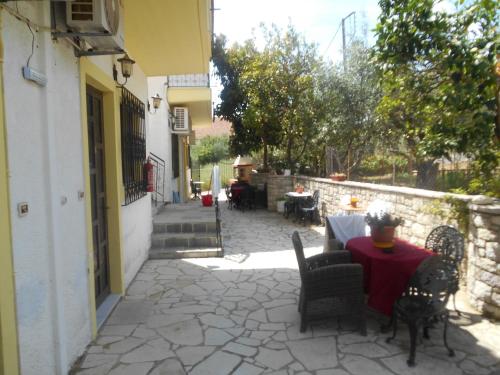 a patio with a table and chairs and a stone wall at Melios Rooms in Petalidhion