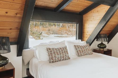 ein Schlafzimmer mit einem weißen Bett und einem Fenster in der Unterkunft Golf and Ski at Pond View - Spectacular barn style cabin on the Golf Course with Hot Tub! in Big Bear Lake