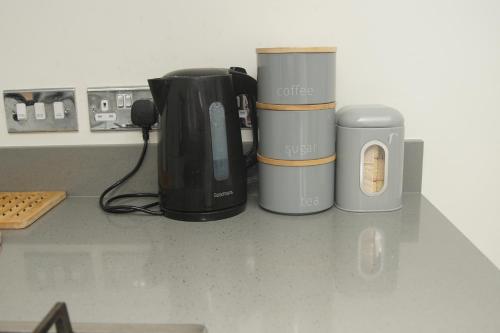 three coffee cups sitting on top of a counter at Deluxe City Centre 4 Bedroom Entire Town House in Leeds