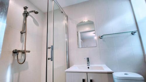 uma casa de banho branca com um chuveiro e um lavatório. em 1 Bedroom Annex - Close to Frimley Hospital - Private Entrance em Frimley