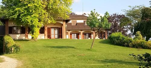 a house with a green lawn in front of it at Villa Pieve in Moncalvo