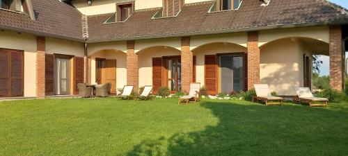 a group of chairs on a lawn in front of a house at Villa Pieve in Moncalvo