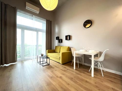 a living room with a yellow couch and a table at Zarembowicza A36 Apartment - Self Check-In 20h - Parking &Lift in Wrocław