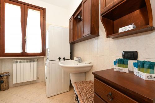 a bathroom with a sink and a toilet and a window at Garda & Golf Apartment in Pozzolengo