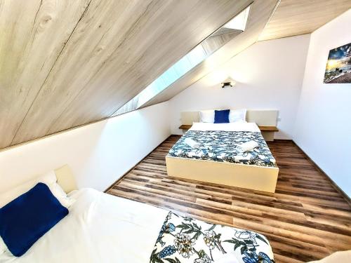 Habitación pequeña con 2 camas y suelo de madera. en apartament centrum, en Władysławowo