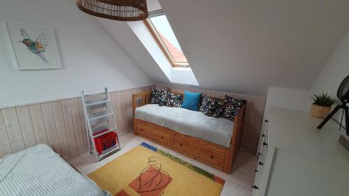 a small attic room with a bed and a window at Szara Czapla in Borowy Młyn