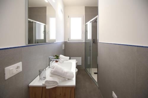 La salle de bains est pourvue d'un lavabo et d'un miroir. dans l'établissement Appartamento Casa vacanza Le Terrazze Via Parigi,23, à Castelsardo