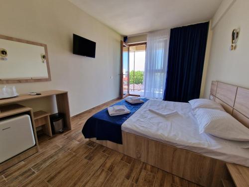 Un dormitorio con una cama grande y un televisor. en Studio 58 Costinesti, en Costinesti