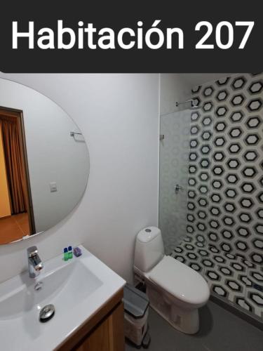 a bathroom with a sink and a toilet and a mirror at Guatapé Country House Hotel in Guatapé