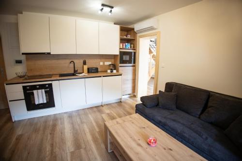 a living room with a couch and a kitchen at Apartmán Lily in Terchová