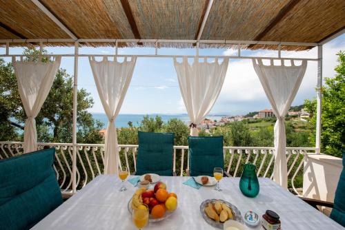 un tavolo con un cesto di frutta sul balcone di Holiday Home Andrija a Podstrana