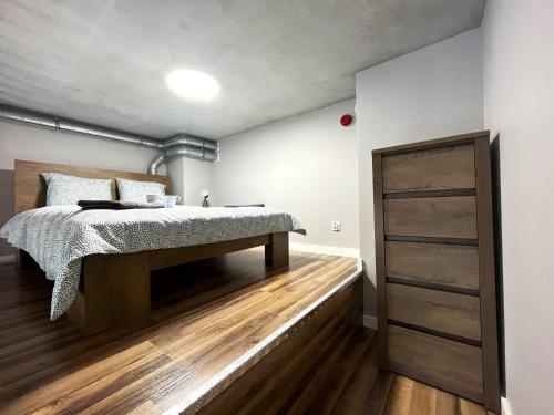 um quarto com uma cama e piso em madeira em Zarembowicza A38 Apartment - Self Check-In 20h - Parking &Lift em Breslávia