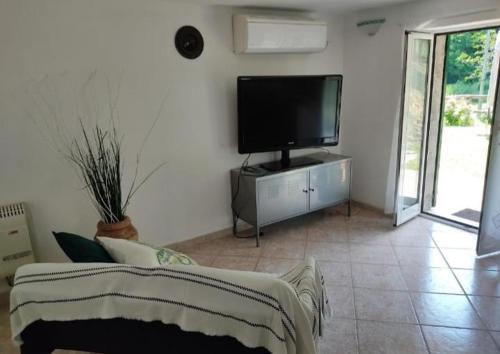 een woonkamer met een tv en een bank bij Casa vacanze Alloro in Mangia