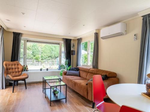 sala de estar con sofá y mesa en Chalet in Grenspark Kalmhoutse Heide near Antwerp en Putte