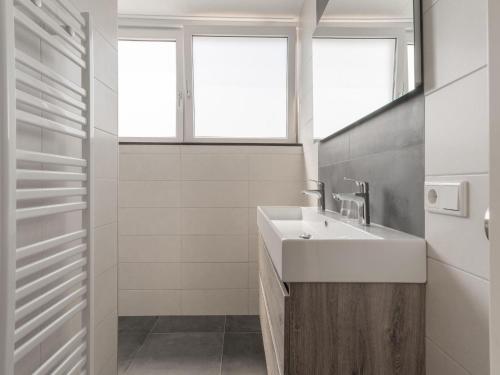 uma casa de banho branca com um lavatório e uma janela em Cozy holiday home in Oploo in a wonderful environment em Oploo