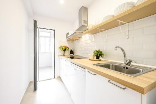 Una cocina con gabinetes blancos y un fregadero. en New apartment city & sea - 3 bedroom - by 10toSea, en Fuengirola
