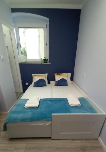- une chambre avec un grand lit aux murs bleus dans l'établissement Apartment Błękitny, à Carolinensiel
