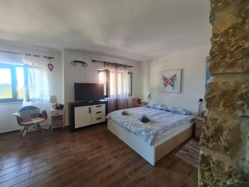a bedroom with a bed and a television in it at Apartment Sunshine in Mali Lošinj