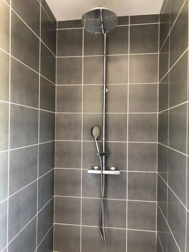 une douche avec pommeau de douche dans une salle de bain dans l'établissement Maison Neuve à St-Thégonnec, à Saint-Thégonnec