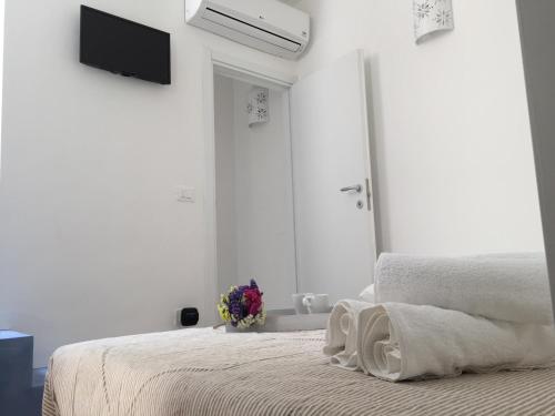 a white bedroom with a bed and a mirror at La Casetta 19 in Polignano a Mare