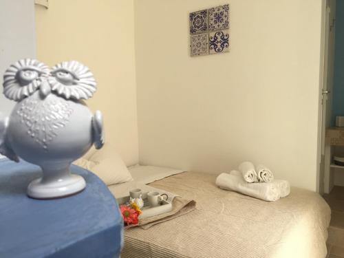 a bedroom with a bed with a vase on a table at La Casetta 19 in Polignano a Mare