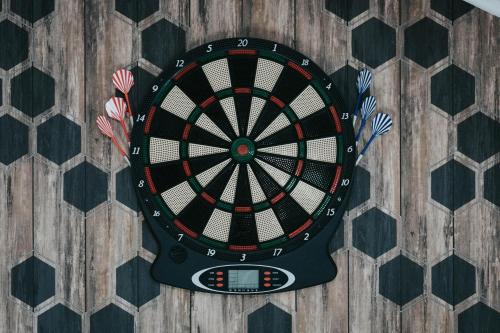 a dart board with darts on a wooden floor at Les Lilas - Confort - Calme - Wifi in Volvic