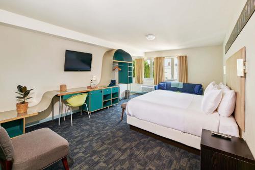 um quarto de hotel com uma cama e uma secretária em Greenporter Hotel em Greenport