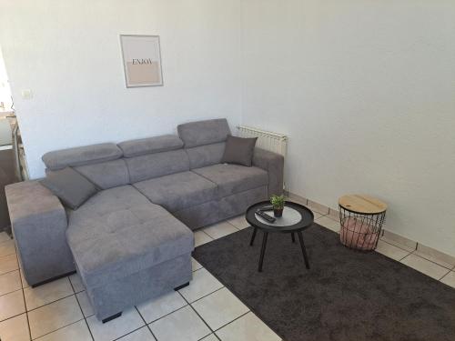 uma sala de estar com um sofá e uma mesa em Chez David em Cholet
