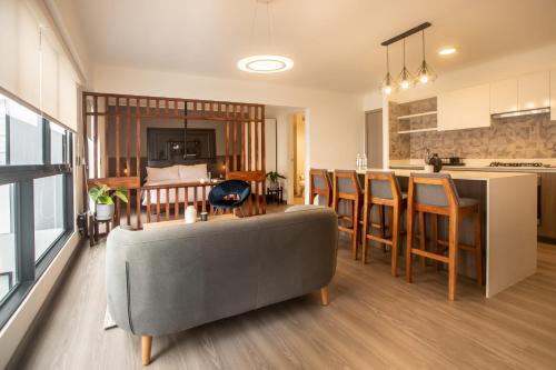 sala de estar con sofá gris y cocina en Solar by Wynwood House, en Lima
