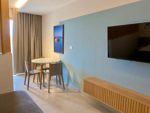 um quarto com uma mesa e uma televisão na parede em Flats em Salvador à 150m da praia em Salvador