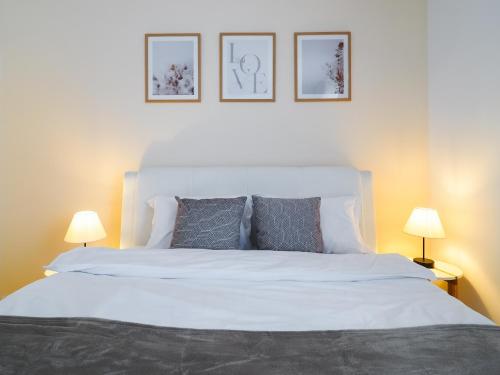 een slaapkamer met een groot wit bed met twee lampen bij Bohemian Bliss in Sibiu