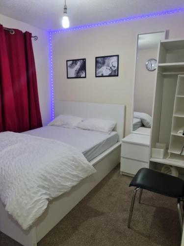 een slaapkamer met een wit bed en een rood gordijn bij SOFT PILLOW in North Woolwich