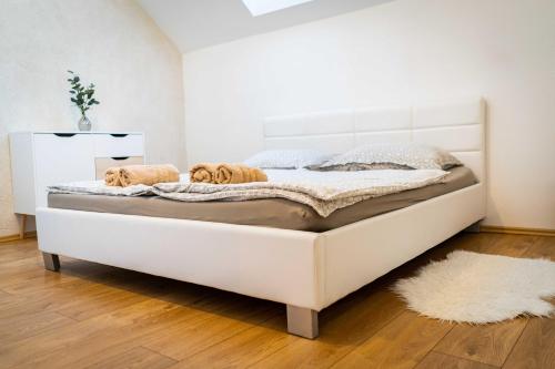 ein großes weißes Bett in einem Zimmer mit Holzboden in der Unterkunft Apartmán ZA-KA 3 ubytování Litovel in Červenka