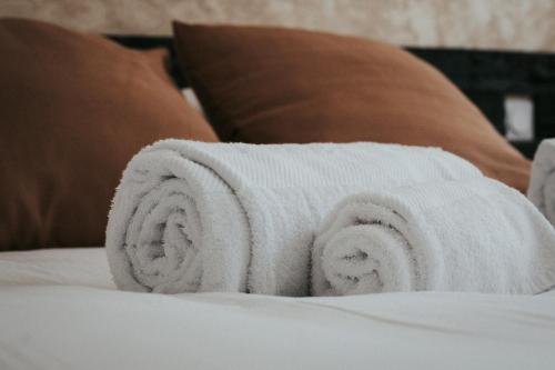 a pile of towels sitting on top of a bed at Les Lilas - Confort - Calme - Wifi in Volvic