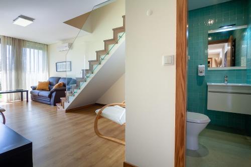 a living room with a toilet and a staircase at Villa Redouça in Cedrim