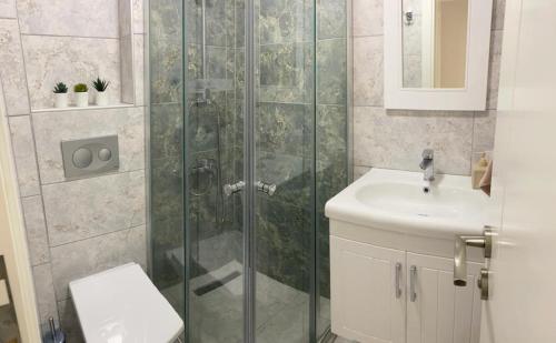 a bathroom with a shower and a toilet and a sink at Rahat Ev in Bodrum City