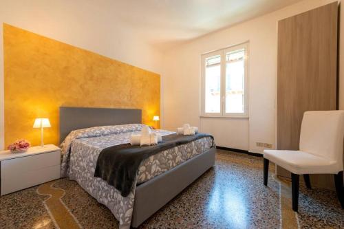 a bedroom with a bed and a chair and a window at Casa Daniele - Centralissima sul porto di Rapallo in Rapallo
