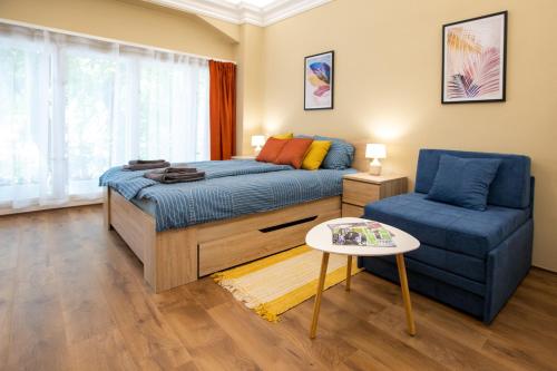 een slaapkamer met een bed en een blauwe stoel bij Center Point in Subotica