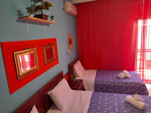 a bedroom with two beds and red curtains at Faros in Platamonas