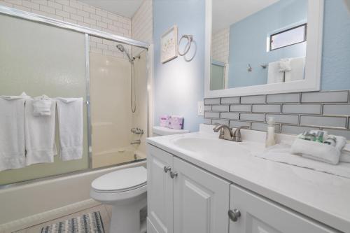 Un baño blanco con lavabo e inodoro. en Aqua Dreams - Six fireplaces, arcade machine, foosball, and hot tub, en Big Bear City