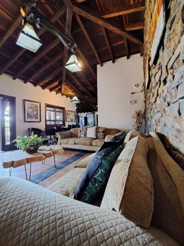 a living room with couches and a stone wall at Guatapé Country House Hotel in Guatapé