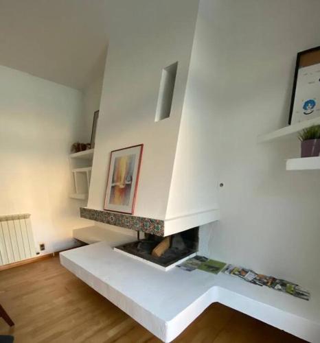 - un salon avec une cheminée dans une pièce blanche dans l'établissement Mas en cœur de ville, à Cavaillon