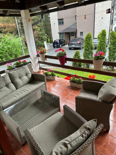 a patio with a couch and chairs on a porch at Vila Nikola Zlatibor in Zlatibor