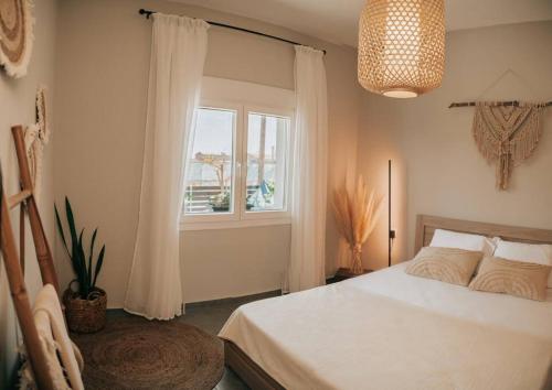 a bedroom with a white bed and a window at Sophia's Coastal Retreat in Korinos