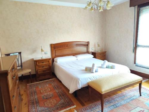 a bedroom with a bed and a dresser and a desk at Bermeo Kaia in Bermeo