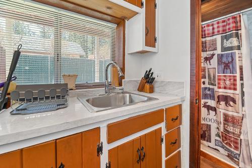 una cocina con fregadero y ventana en The Vintage Bear Cabin - wonderful, well appointed cabin with a native rock fireplace!, en Big Bear City