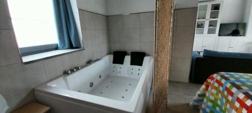 baño con bañera blanca y ventana en El Molino 4 en Muros de Nalón