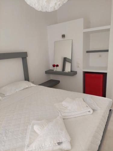 a bedroom with a white bed with towels on it at Golden Star Praxitelous in Agia Marina Aegina