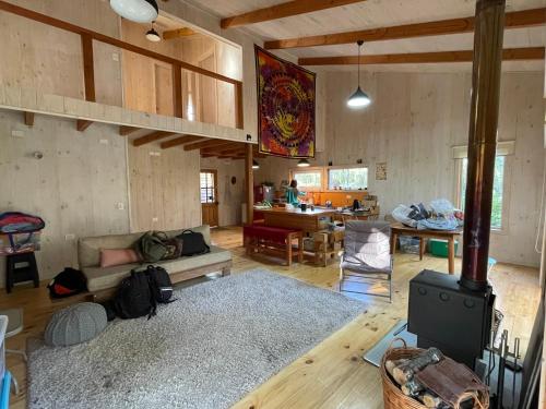a living room with a couch and a stove at Cabaña Icalma, ahora con Tinaja in Curacautín